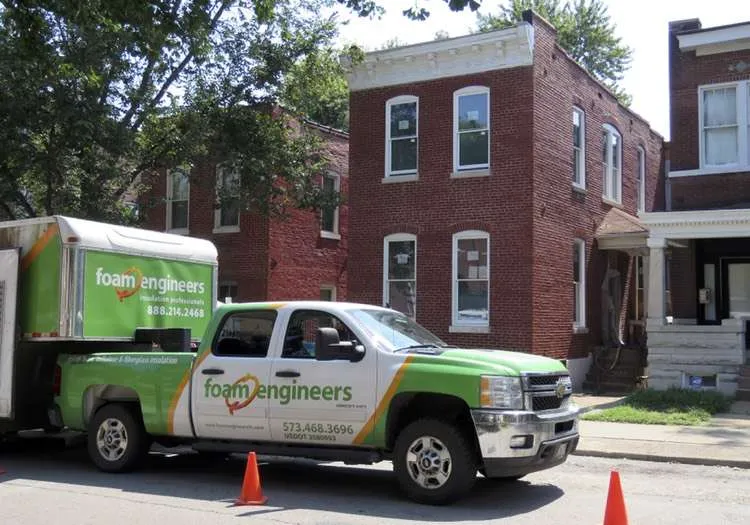 A truck is parked in front of a brick building.